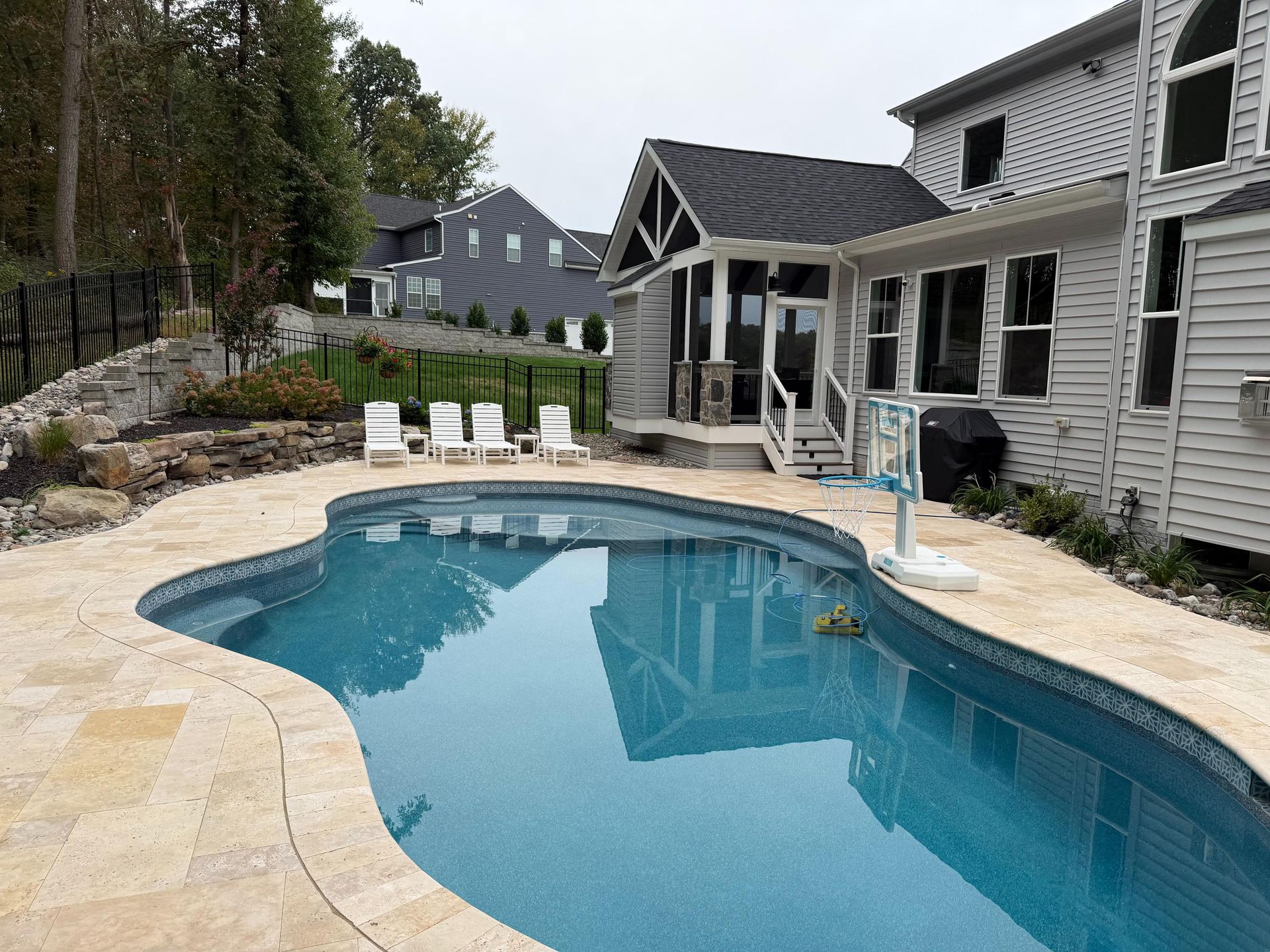 Freeform swimming pool with wide patio deck and lounge seating