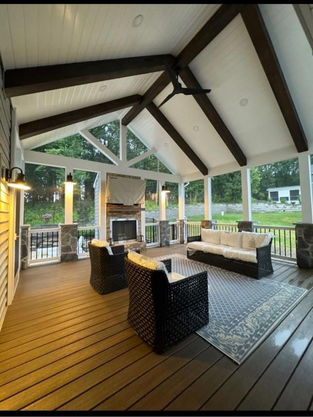 Outdoor pavilion interior with stone fireplace and timber ceiling