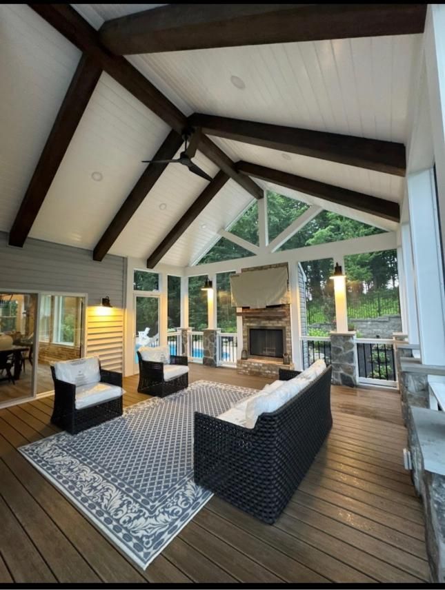 Covered outdoor living pavilion with stone fireplace and vaulted ceiling