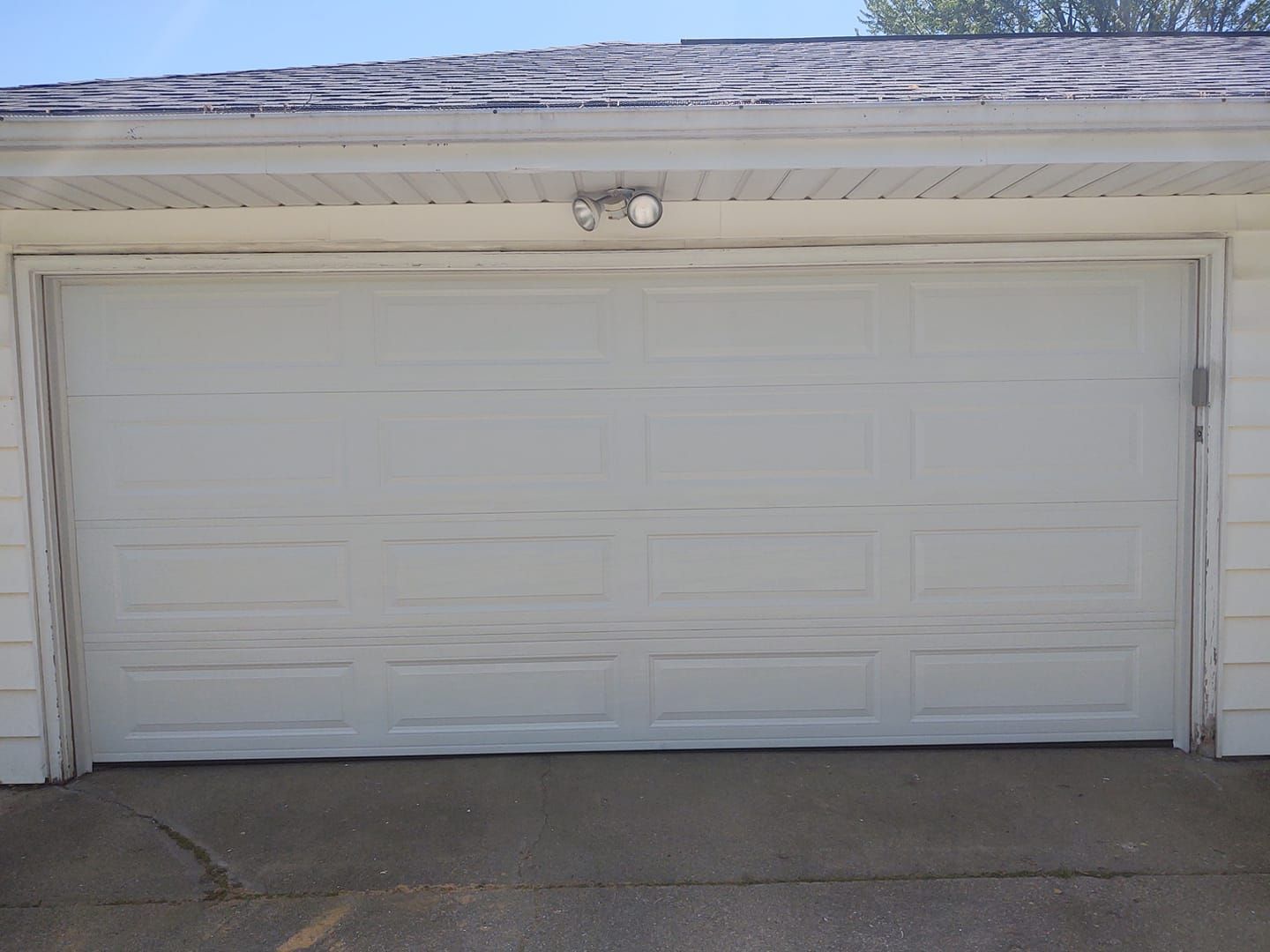 A white garage door is open on a house.