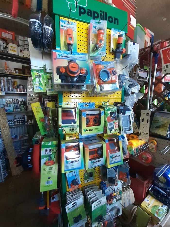In un corridoio di un negozio, coloratissimi articoli per animali domestici sono esposti appesi, con spazzole e accessori confezionati su ganci.