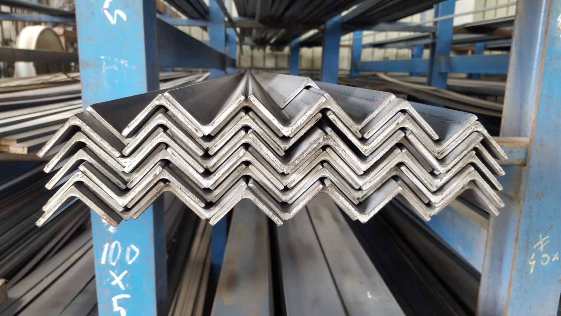 Un mucchio di pezzi di metallo sono accatastati uno sopra l'altro in un magazzino.
