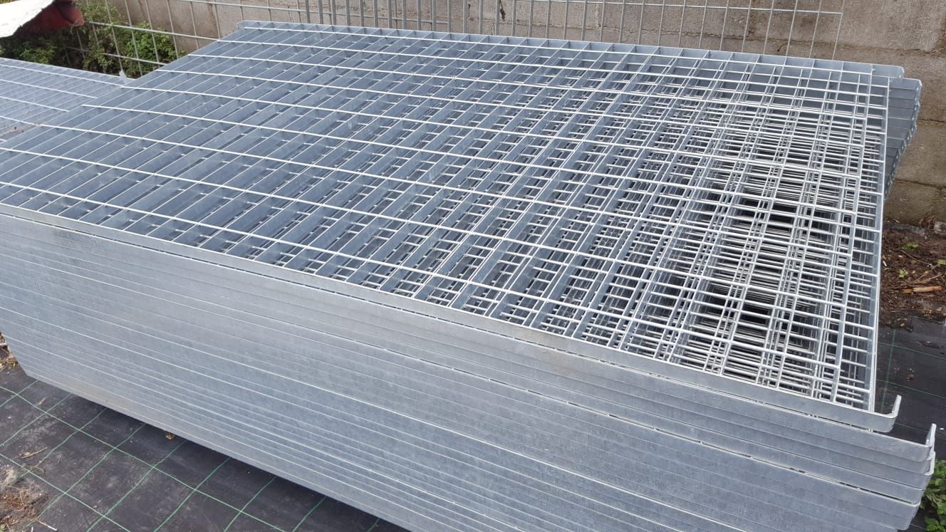 Una pila di grate metalliche appoggiate una sull'altra sul terreno.