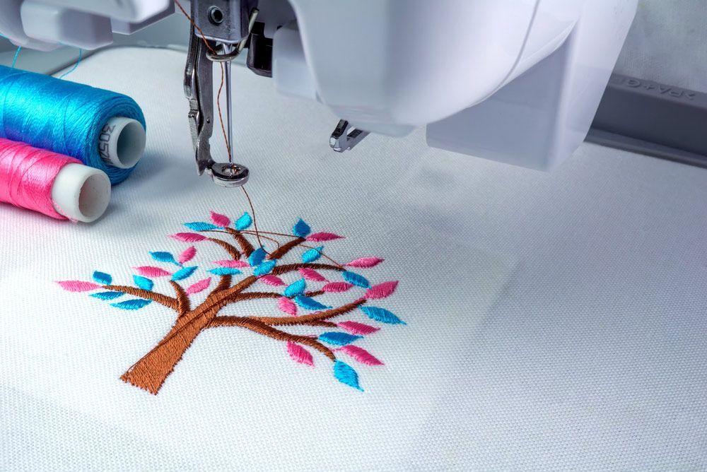 A Sewing Machine is Embroidering a Tree on a Piece of Fabric — Embroidery Express in Nambour, QLD