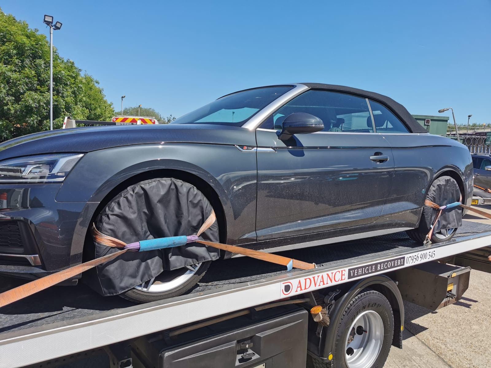 Flatbed tow truck assisting a broken-down car in London