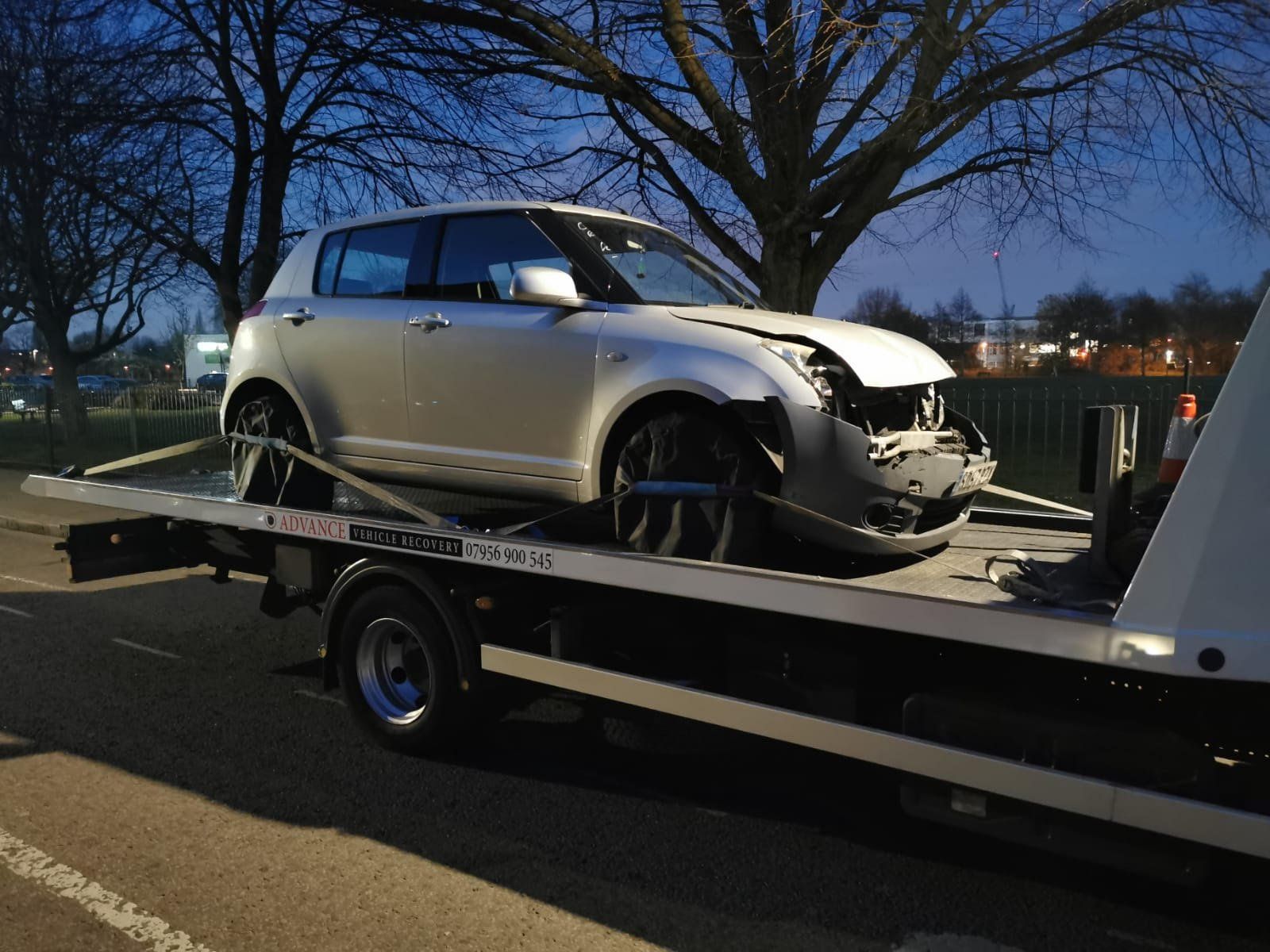 Flatbed tow truck assisting a broken-down car in London