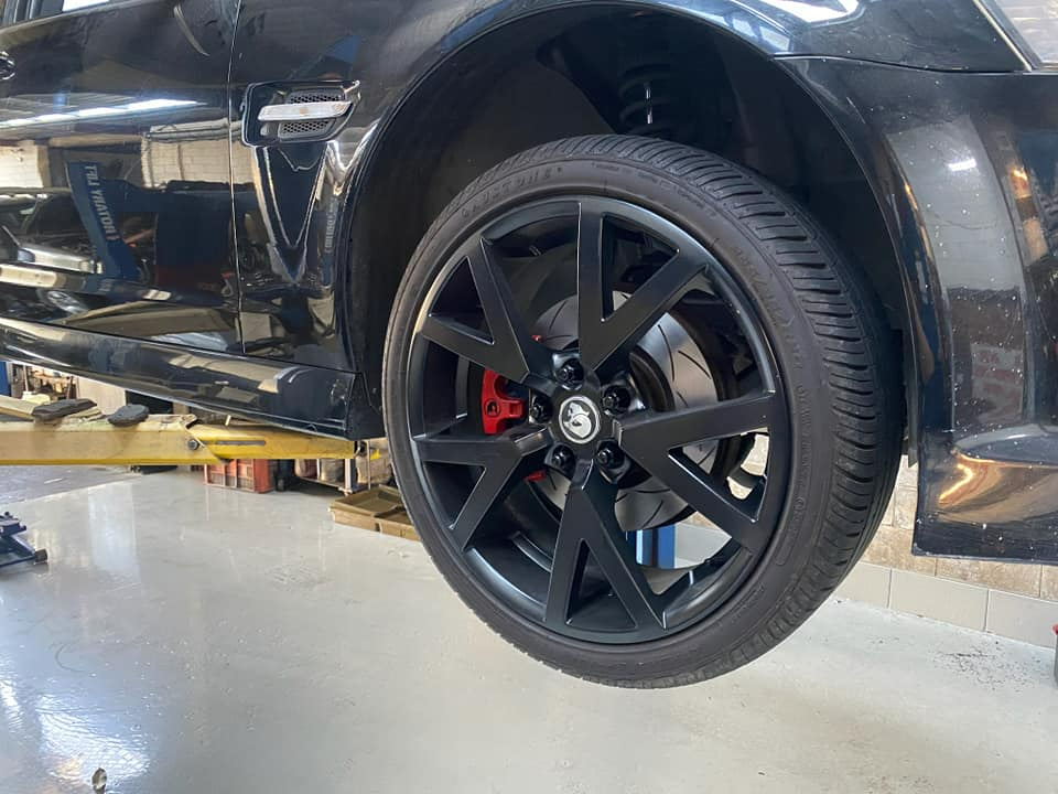 A Black Car Is Sitting On A Lift In A Garage β Town Automatics 4WD & Mechanical in South Townsville, QLD