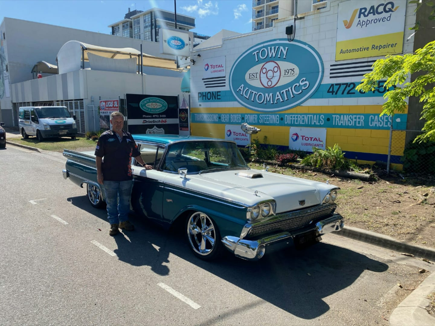 A Man Is Standing Next To A Blue And White Car β Town Automatics 4WD & Mechanical in South Townsville, QLD