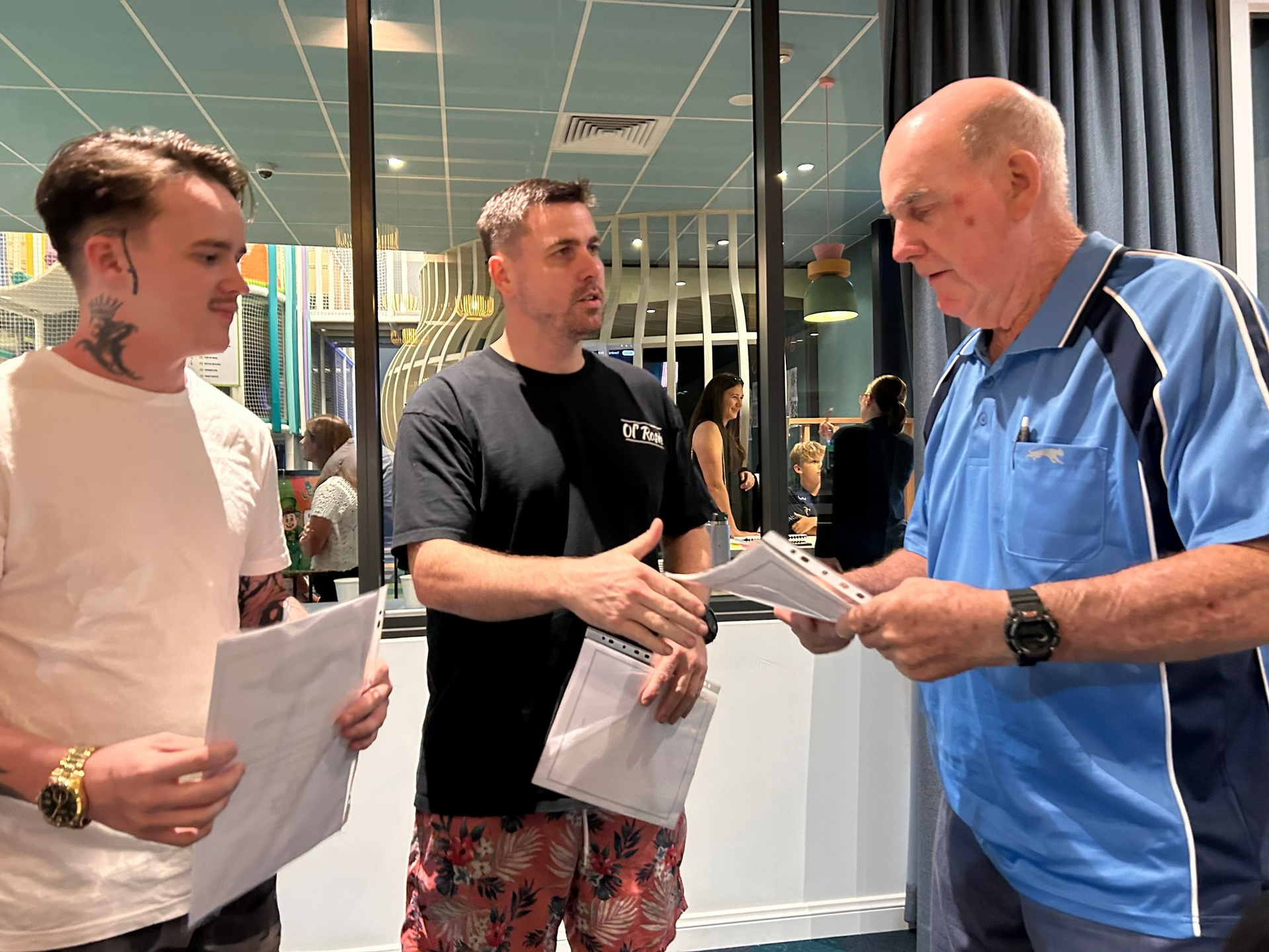 Three Men Are Standing Next To Each Other In A Room Holding Papers β Town Automatics 4WD & Mechanical in South Townsville, QLD