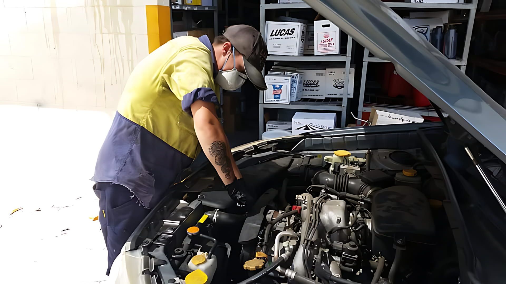 A Man Is Working Under The Hood Of A Car — Town Automatics 4WD & Mechanical in South Townsville, QLD