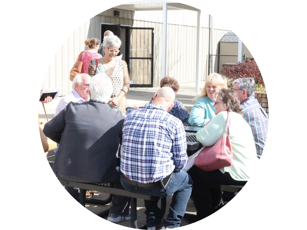 A group of people are sitting around a picnic table.