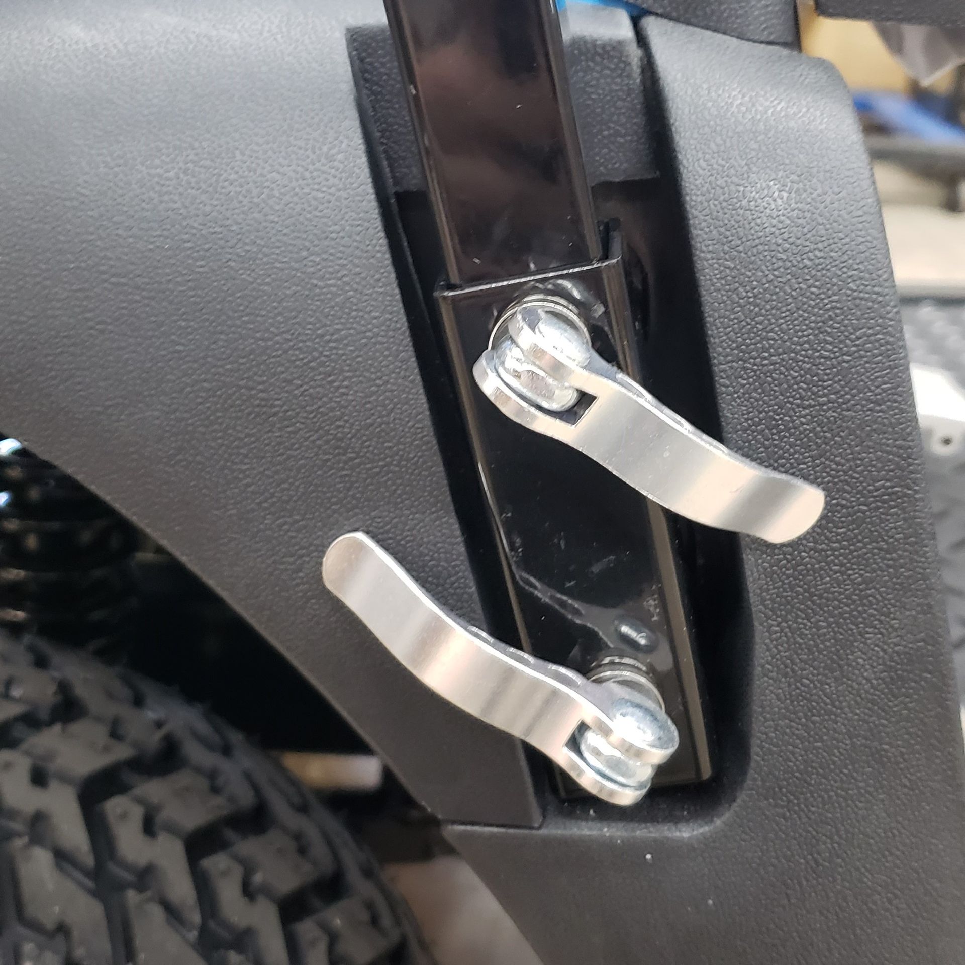 A close-up of a black fender with two metal handles attached to it