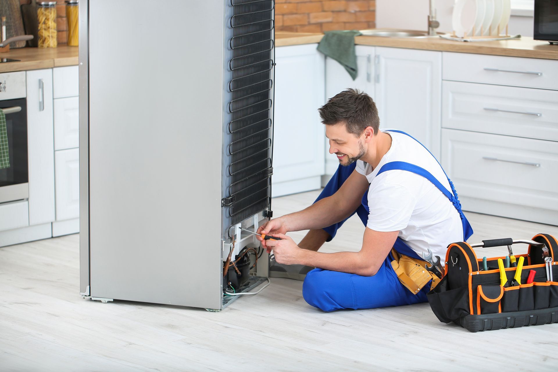 Technician in red gloves working on exposed electrical panel beside a window