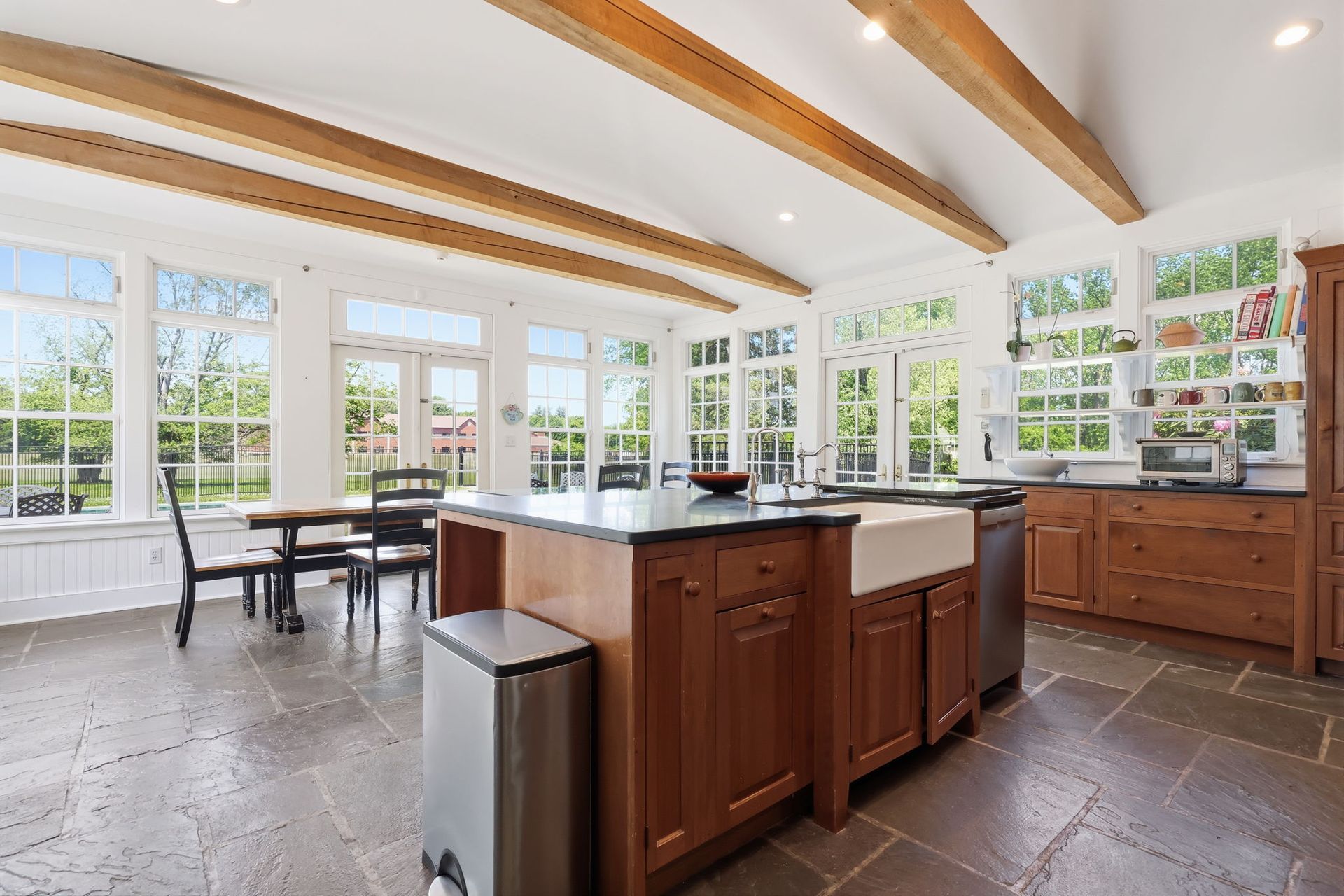 Bright modern kitchen with wood cabinets, central island, and large sunlit windows