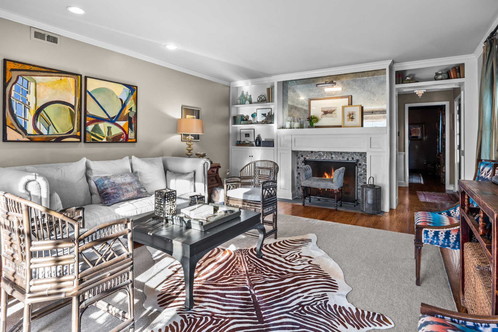 Living room with couch, fireplace, artwork, and patterned rug.