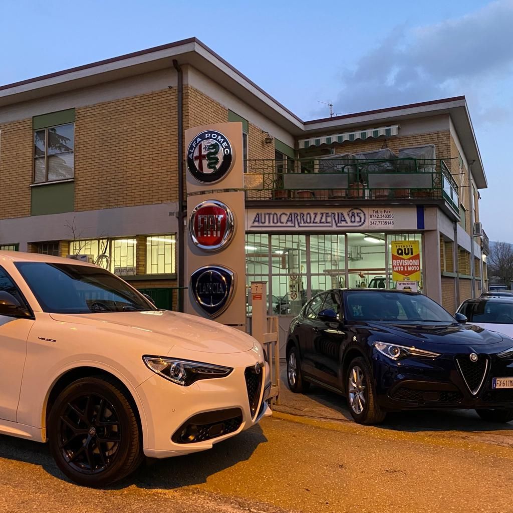 Auto parcheggiate fuori da una concessionaria Alfa Romeo e Fiat