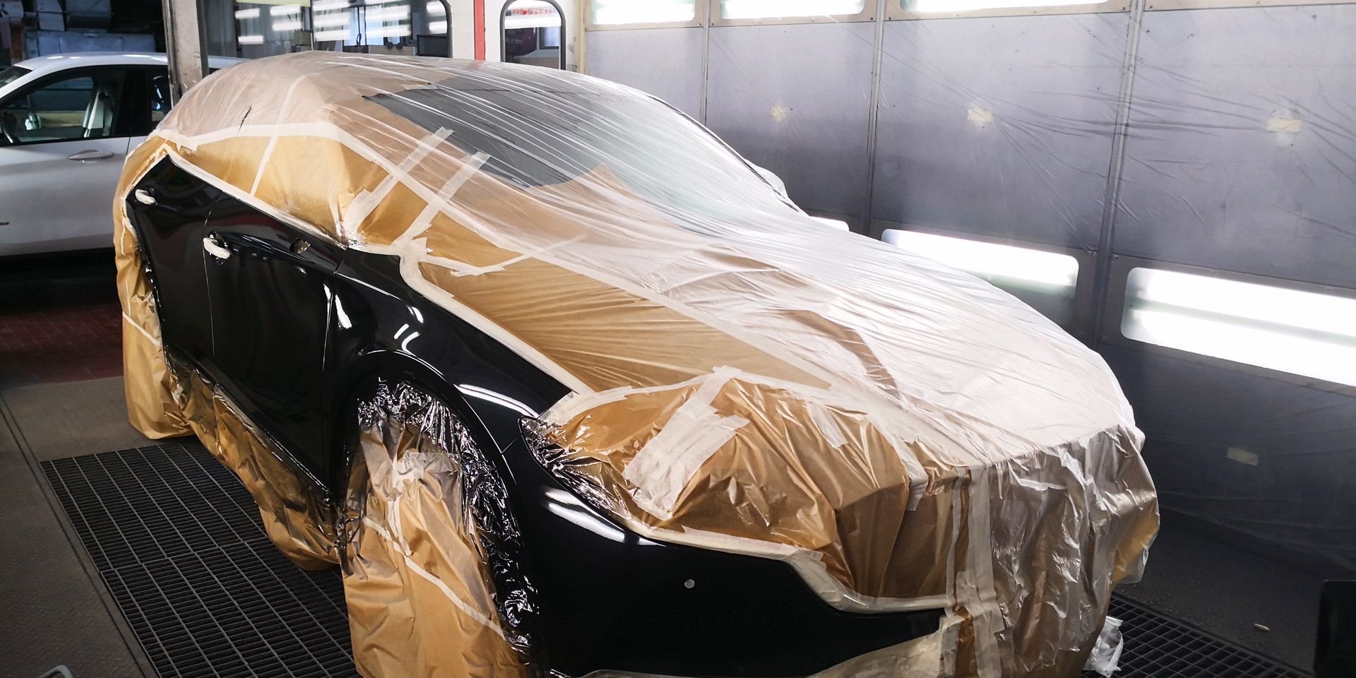 Un'auto nera è ricoperta da teli 
