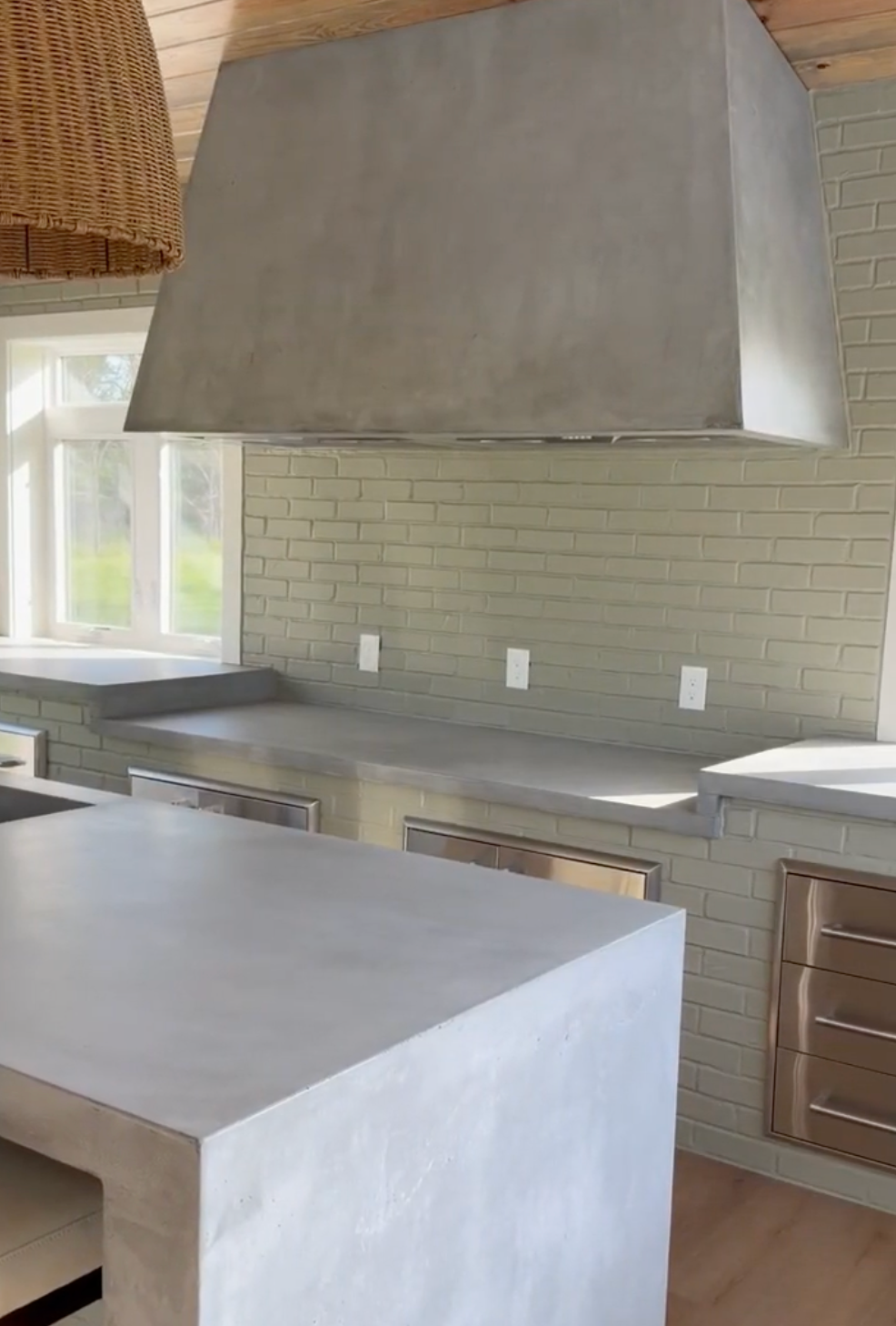 Modern kitchen with gray range hood, white subway tile backsplash, and gray island counter