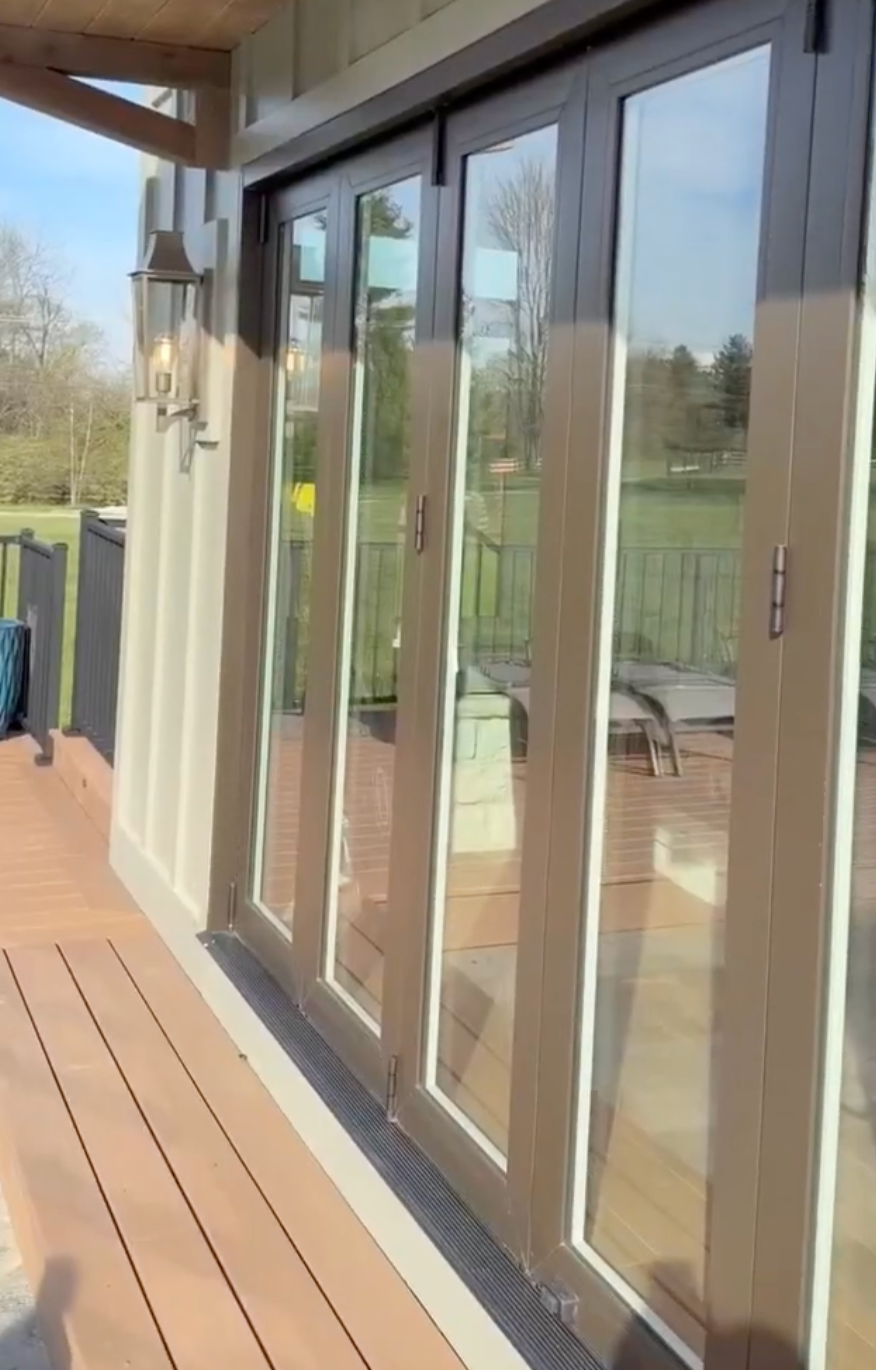Sliding glass doors opening onto a wooden deck in a bright outdoor setting