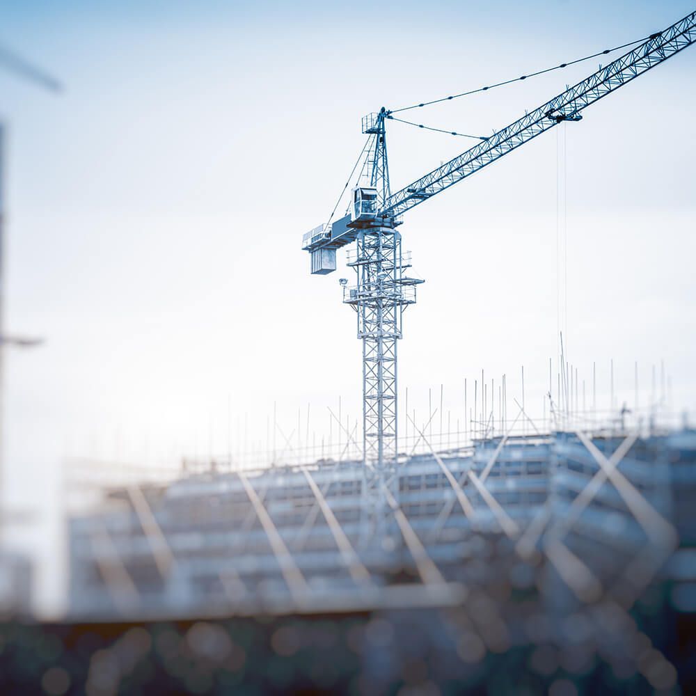 A construction site with a crane in the foreground.
