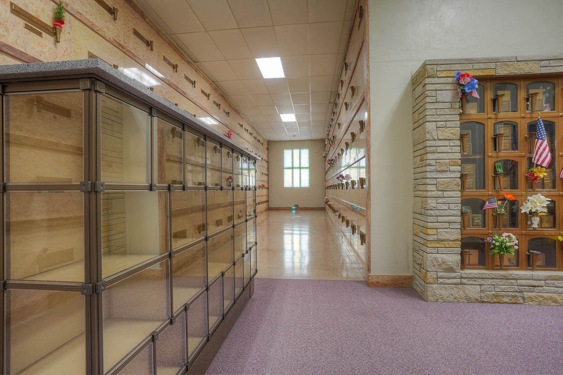 School hallway with glass display cases and a doorway decorated with colorful artwork