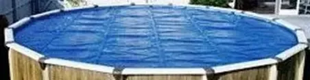 Blue above-ground pool with a wooden fence and white supports