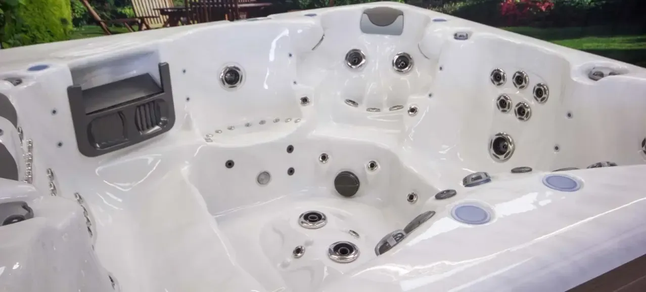 White outdoor hot tub with multiple jets, cup holders, and built-in headrests
