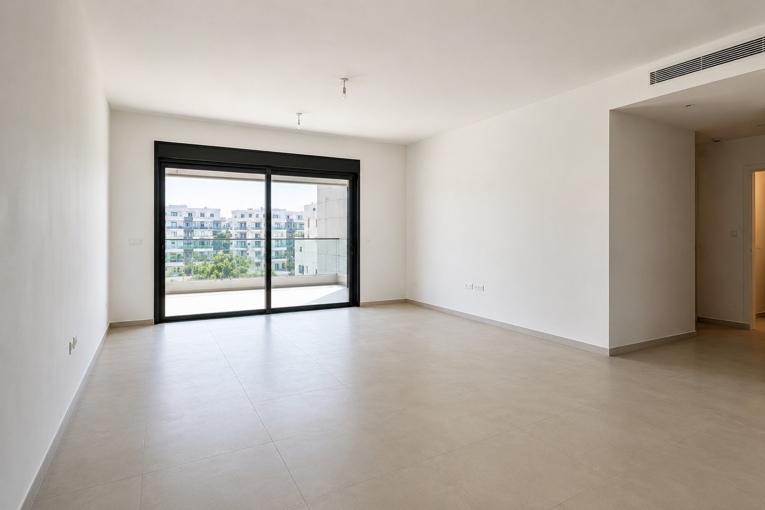 Empty modern living room with beige tile floor and large sliding glass doors to a balcony.