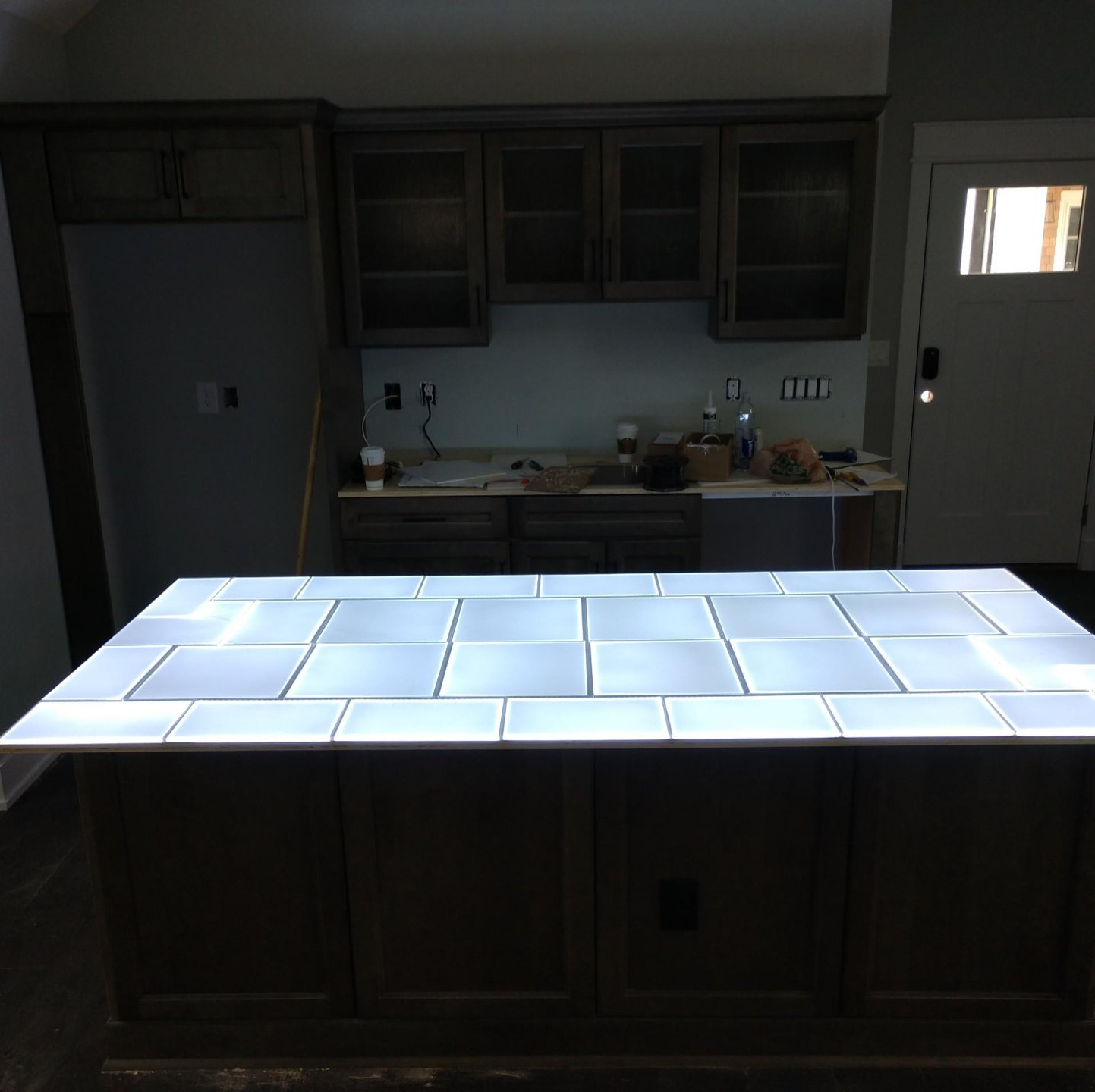 Kitchen with wooden cabinets, a tile island, and a stainless steel sink by Shoreline Electric OBX