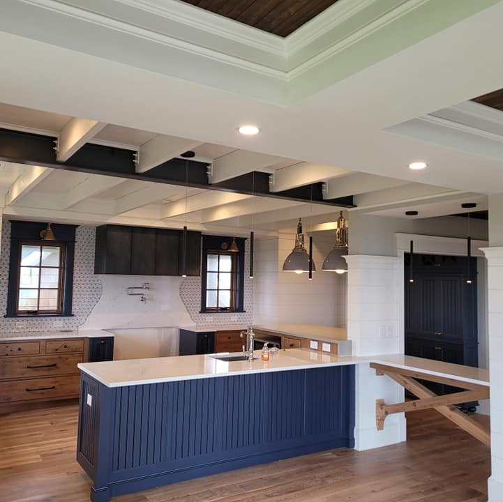 Blue and wood kitchen island with overhead beams and pendant lights by Shoreline Electric OBX