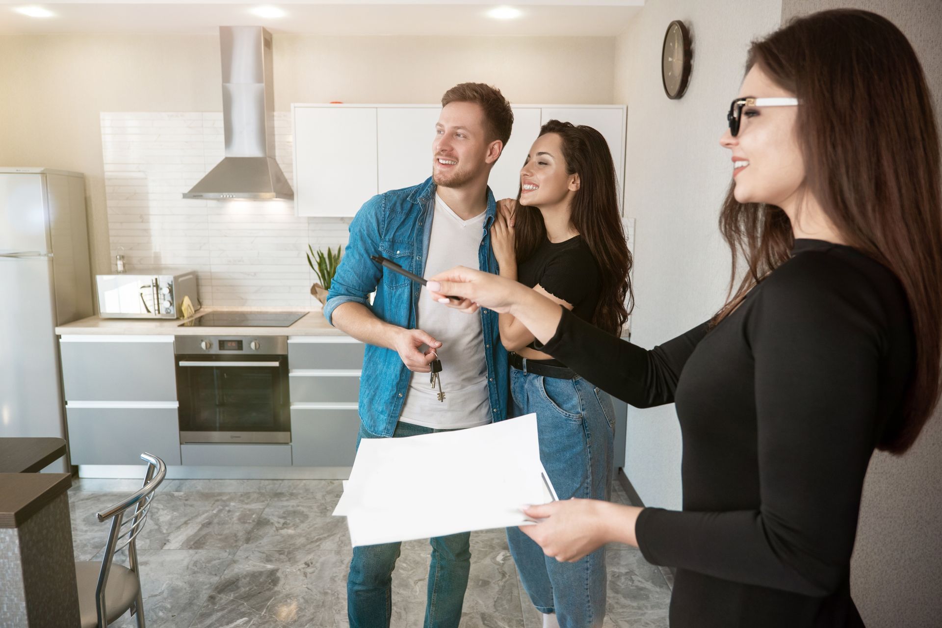 Stock photo of a person showing a couple a home for rent