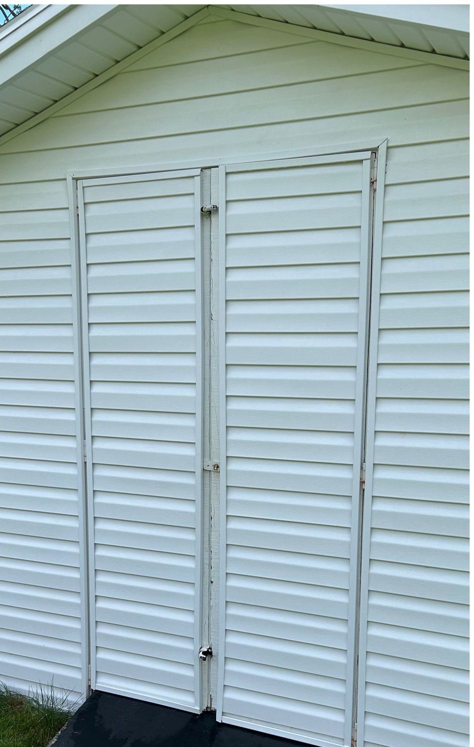A white garage door with a black mat in front of it