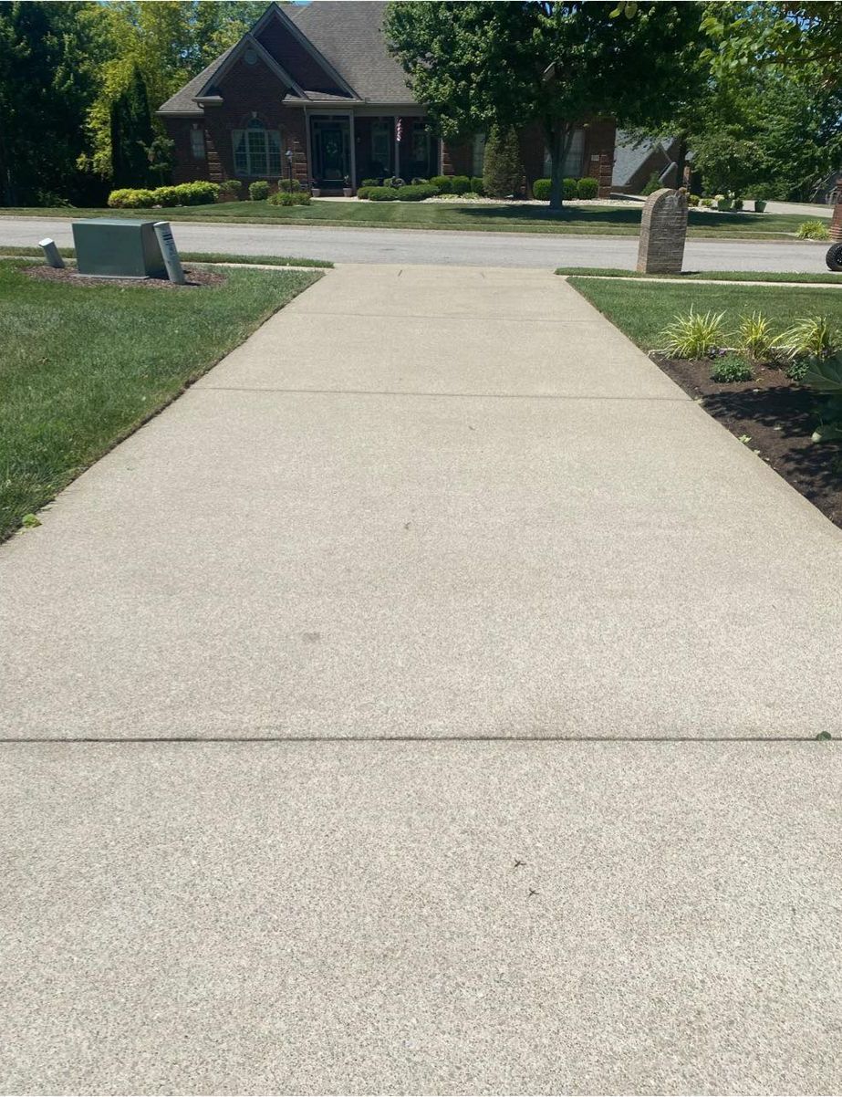A concrete walkway with a house in the background