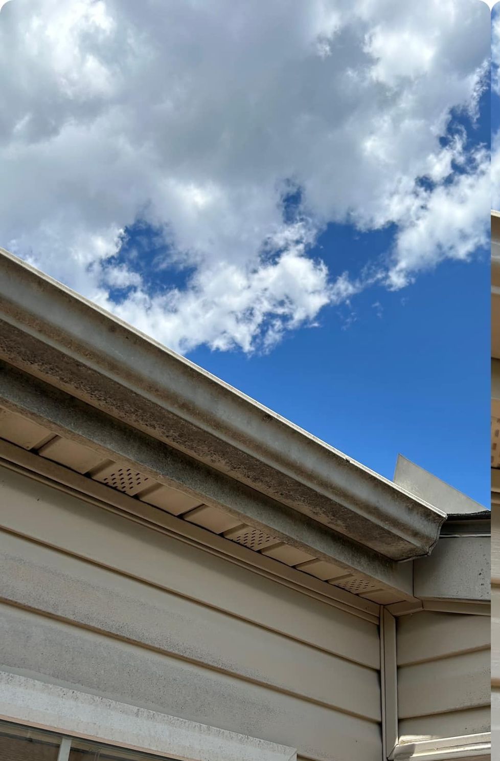 A house with a blue sky and clouds behind it