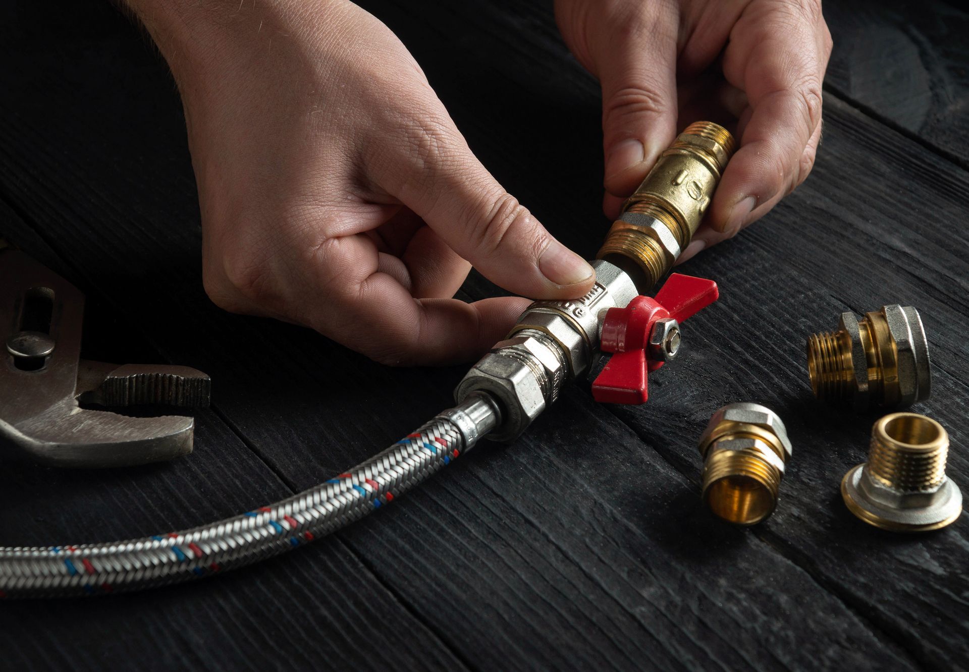 Close-up of a plumber's hands performing a gas fitting service.