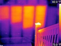 A thermal image of a room with a fence and a window.