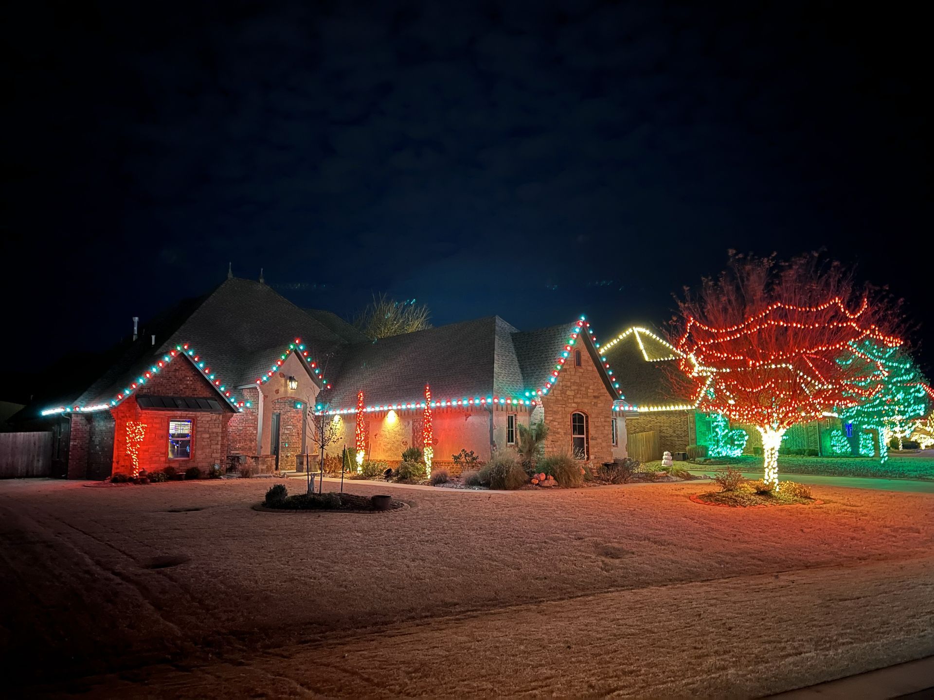 House decorated with colorful Christmas lights at night.
