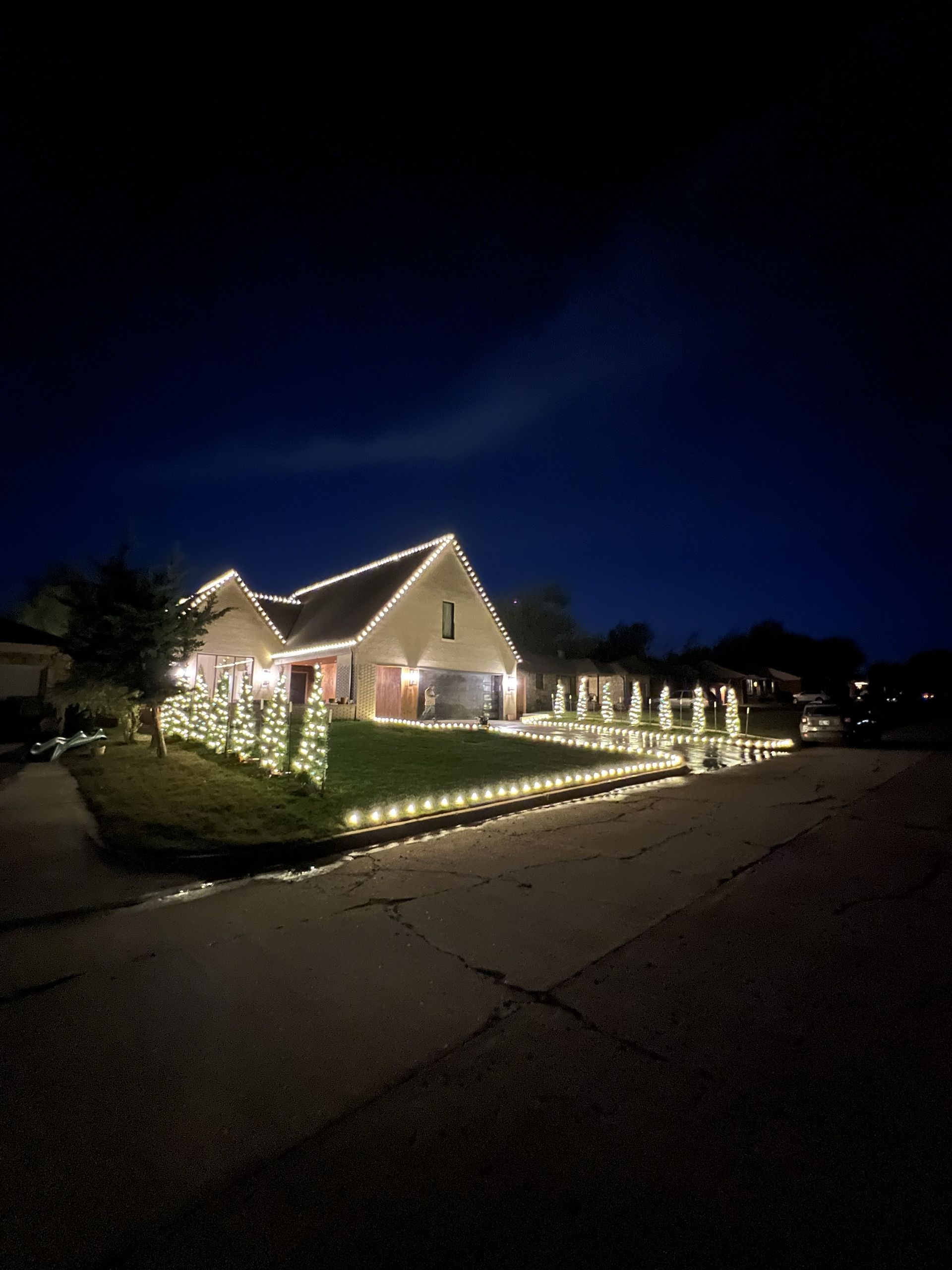 House decorated with white Christmas lights at night.