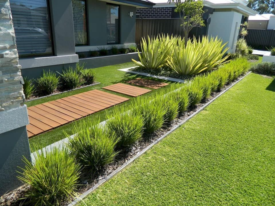 Front yard landscaping with wooden pathway and green shrubs.