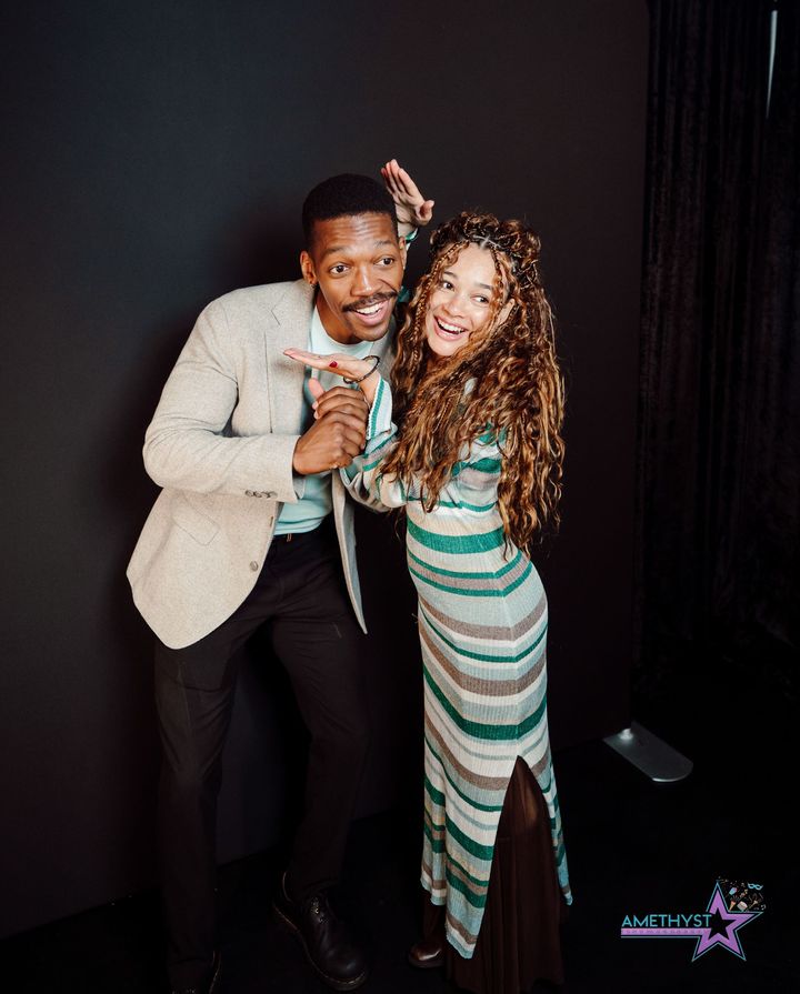 Joyful adult couple posing together at an Amethyst Star Ventures event booth