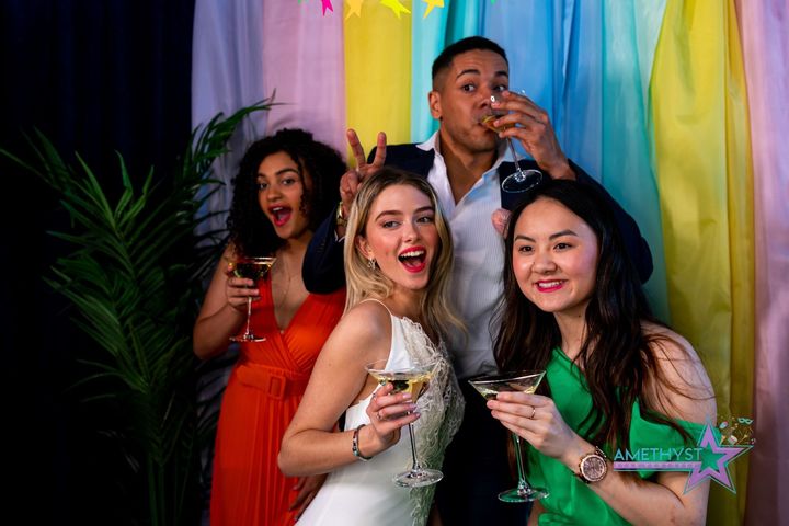 Four adults posing together at an Amethyst Star Ventures event photo booth