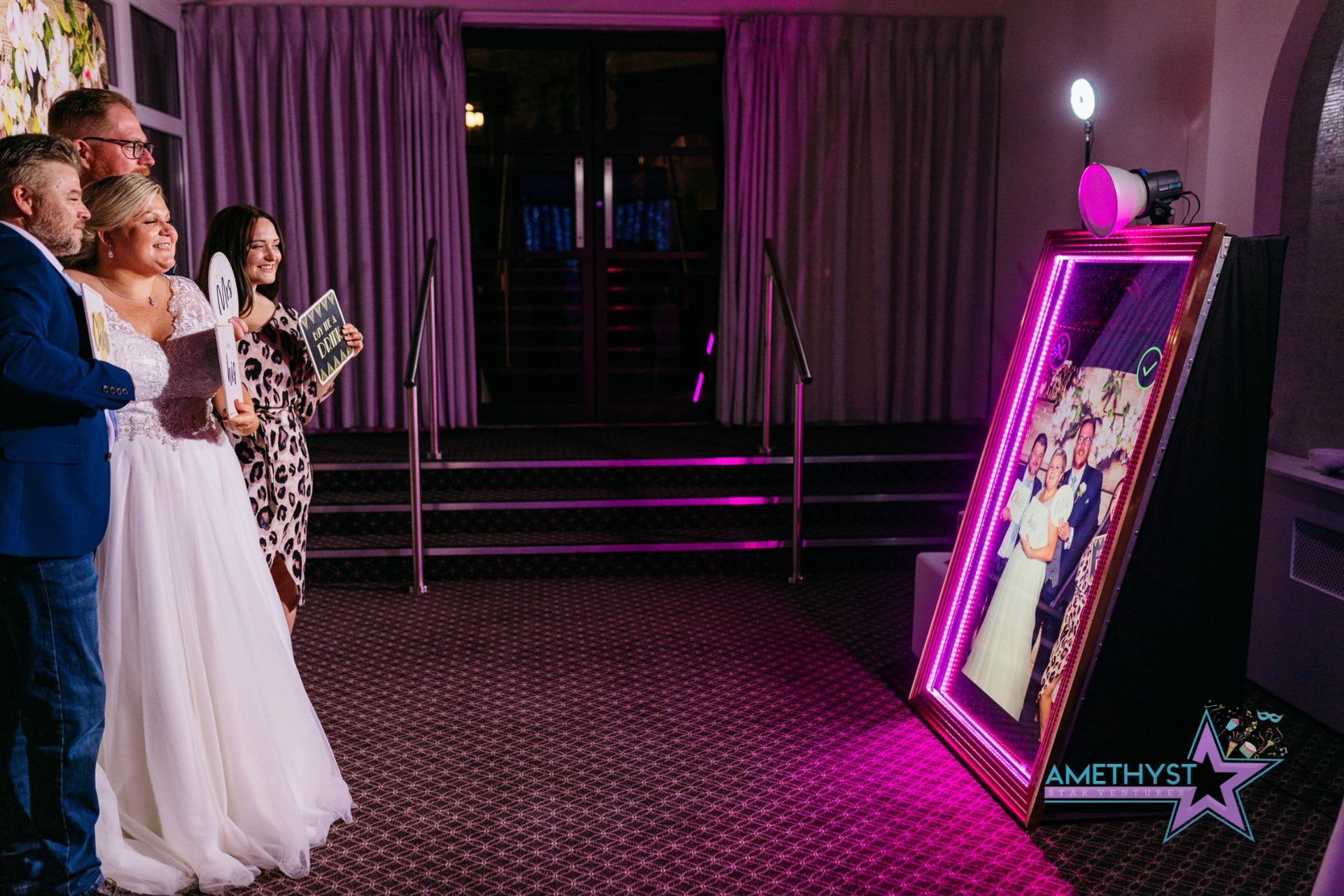 Wedding guests posing with the Mirror Me photo booth from Amethyst Star Ventures in Central Texas