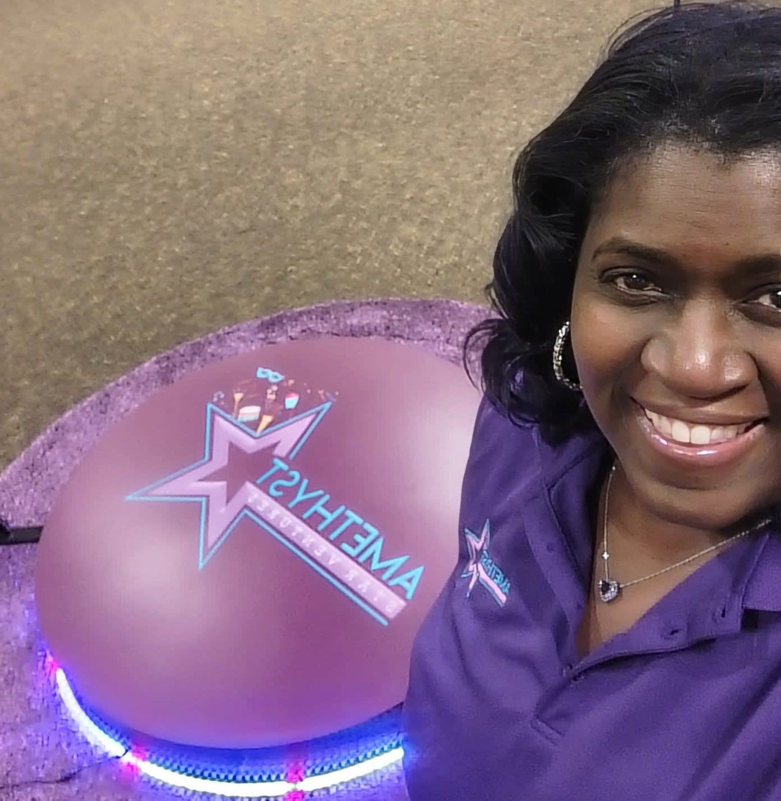 Woman smiling beside a purple balloon with a star logo and the word “TACHEMA” on it