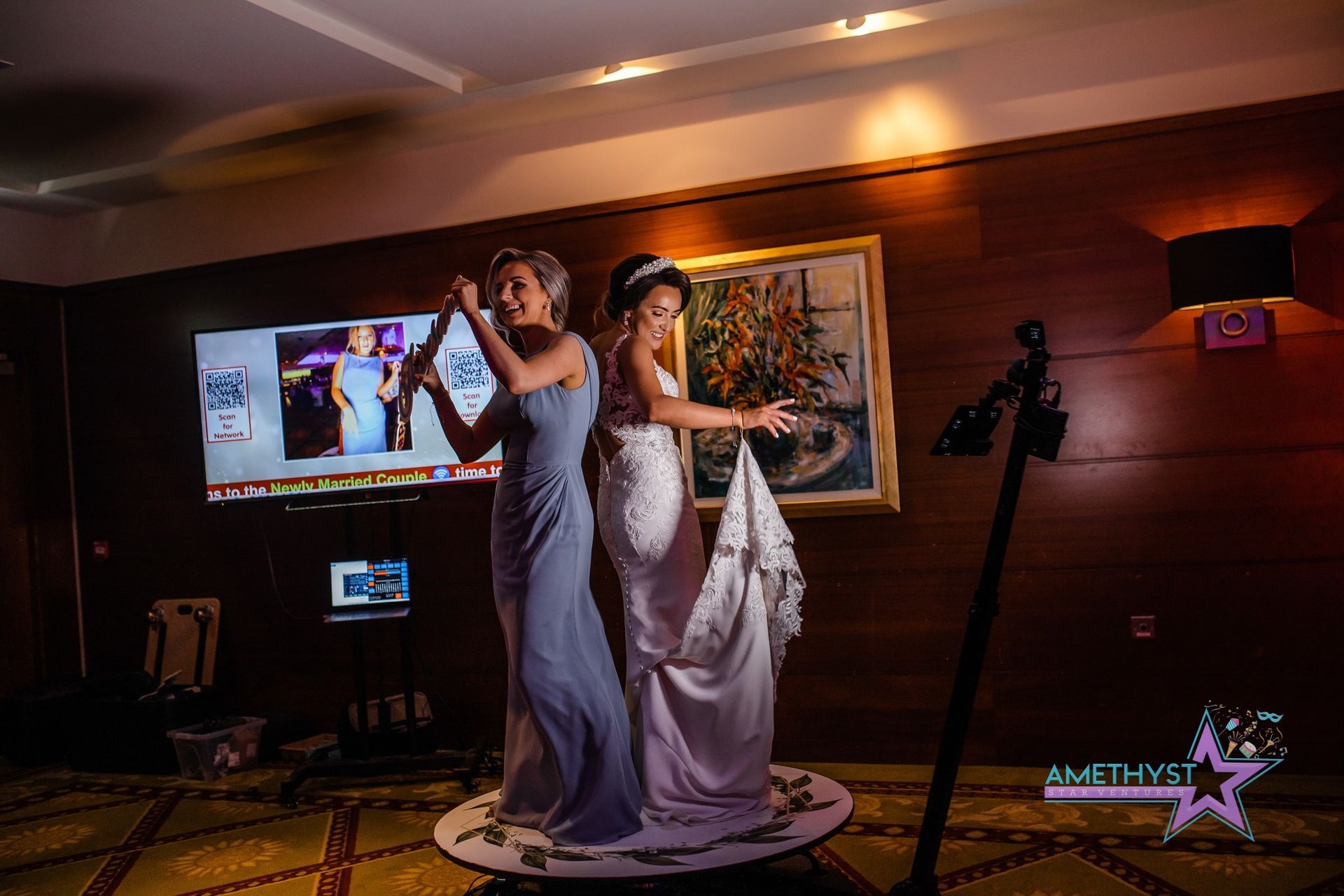 Guests posing at an Amethyst Star Ventures photo booth during an indoor celebration