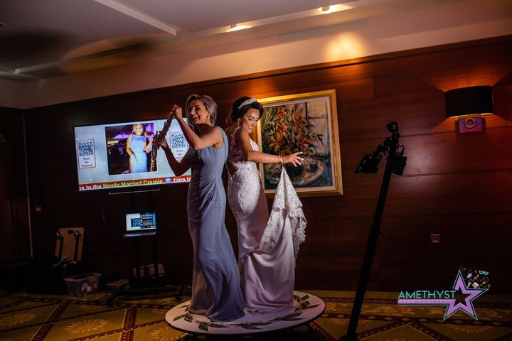 Guests posing at an Amethyst Star Ventures photo booth during an indoor celebration
