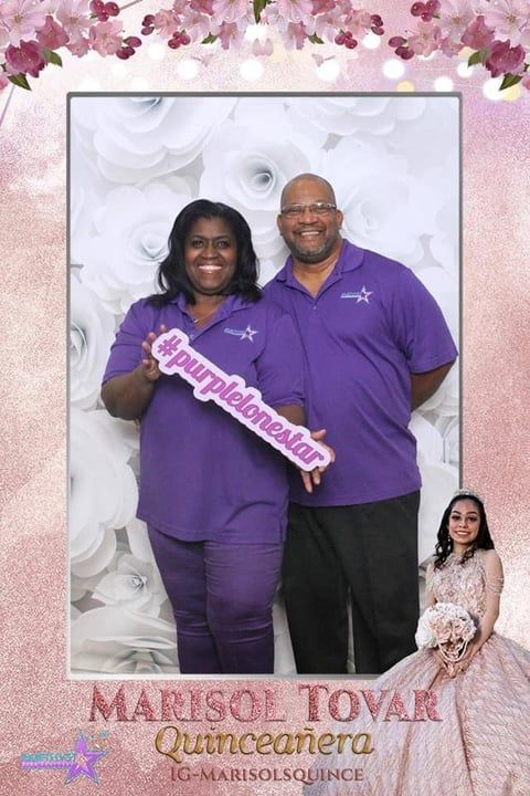 Couple in purple outfits posing with a quinceañera sash and floral backdrop, with quinceañera text below