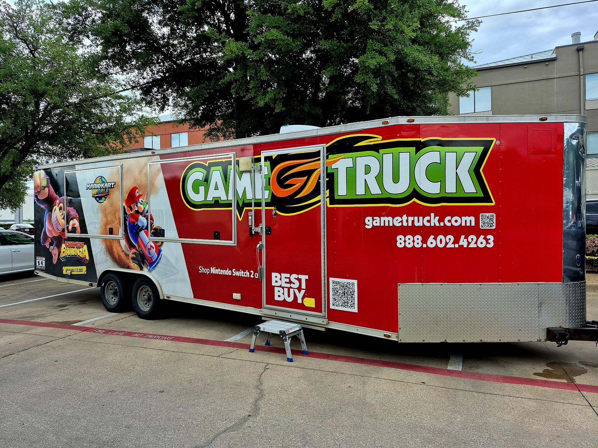 Red Game Truck trailer parked on a street with colorful gaming graphics and white text.