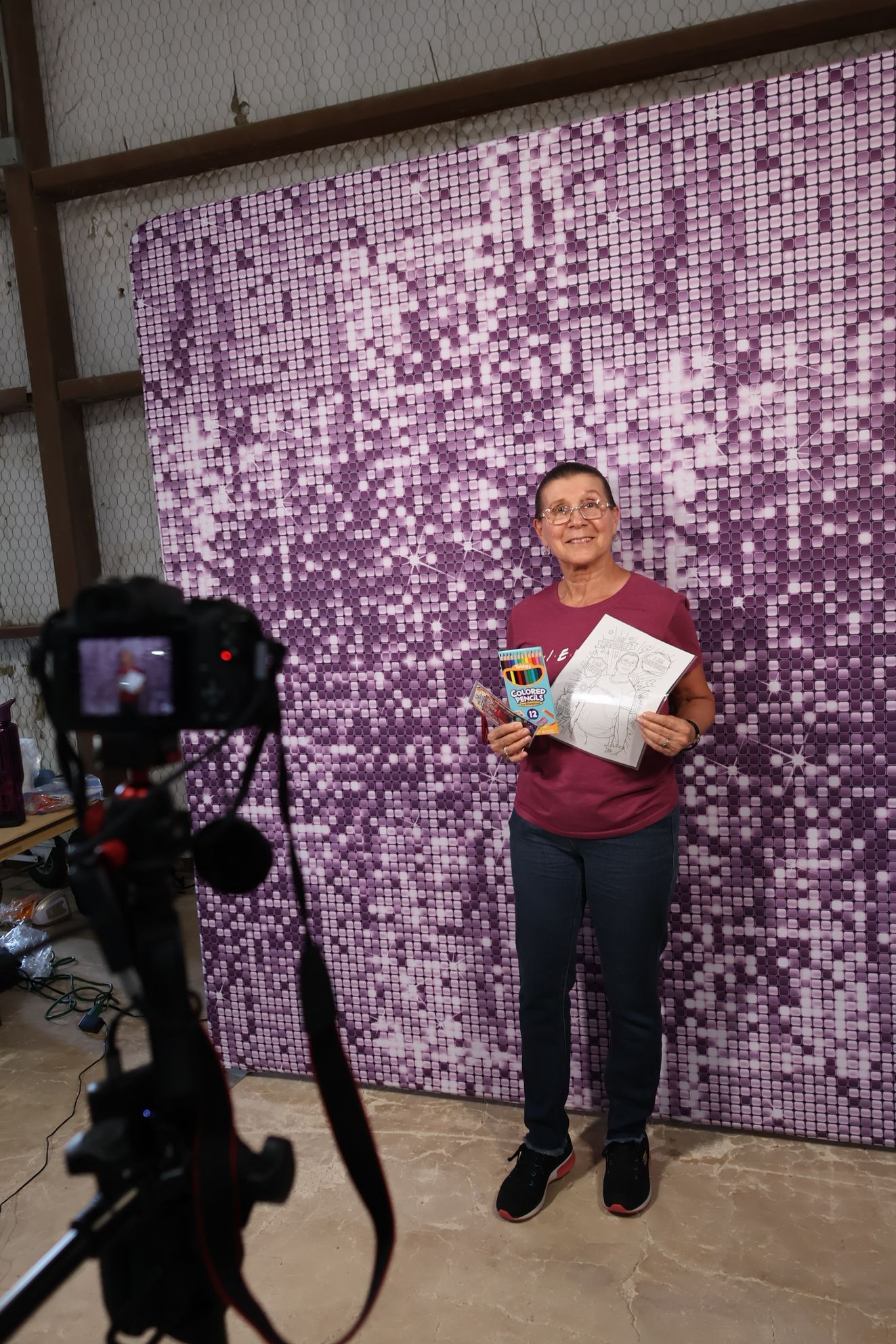 Adult guest holding a personalized Color Me portrait and bookmark at the Bell County Family Success Festival