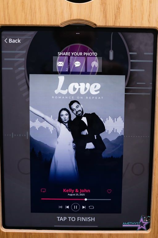 Photo booth screen showing a couple under the word “Love,” with a “Tap to finish” prompt.