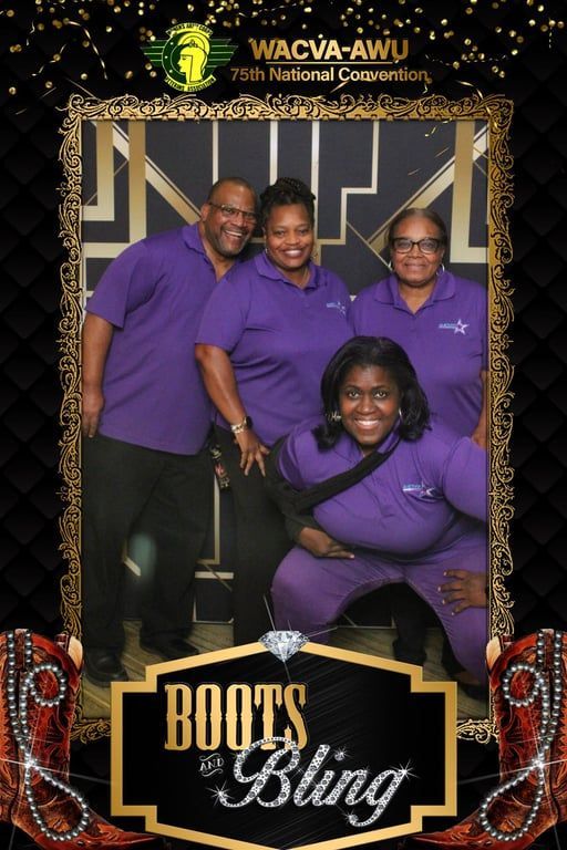 Four people in purple shirts pose at a “Roots & Bling” event backdrop.